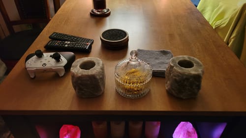 Customer's two gray salt candle holders set up on a wooden table among other personal items.