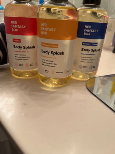 Customer's three bottles from the Fruity Skin Body Oil Bundle—Yummy, Pineapple Crème, and Blueberry Crème—lined up on a counter.