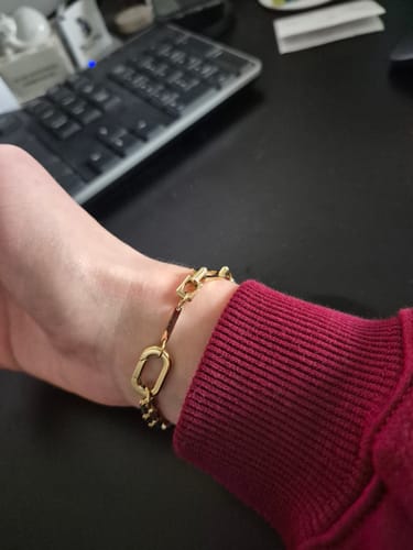 Customer wearing the gold Lovers Chain Bracelet on their wrist, viewed from the side.