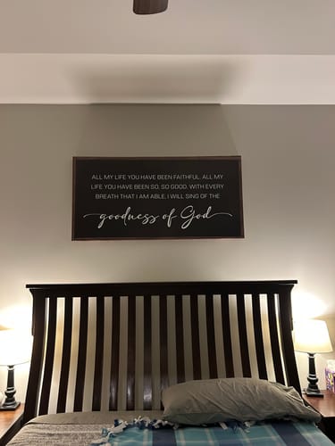 Customer's Goodness Of God Faith Sign II hanging on a bedroom wall above the headboard of a bed.