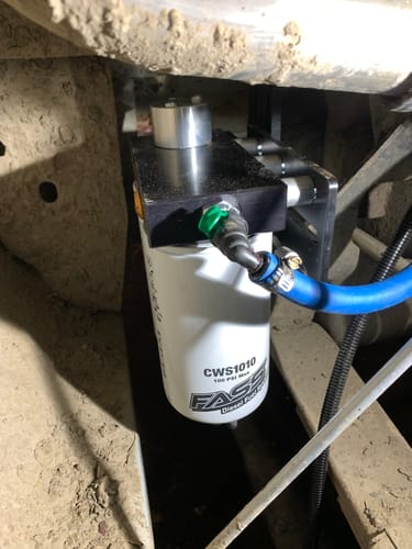 Reviewer's installed Cummins Drop-In Diesel Fuel System under their vehicle, with the filter and blue hose attached.
