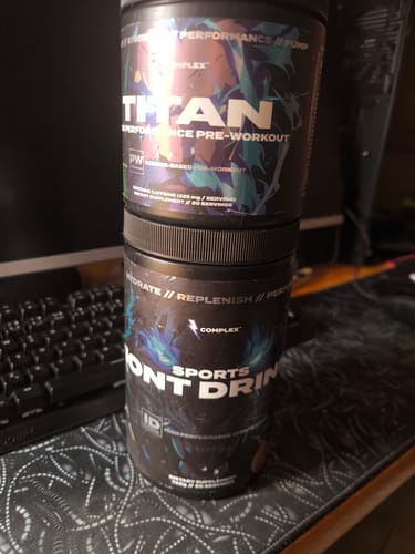 Customer's tub of Sports Iont Drink stacked beneath another supplement container on a desk.