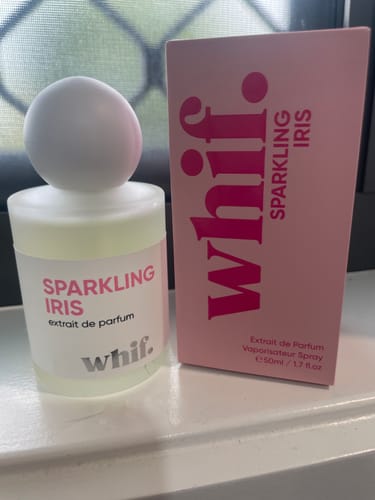 Customer's Sparkling Iris perfume bottle and its pink box displayed on a white windowsill.
