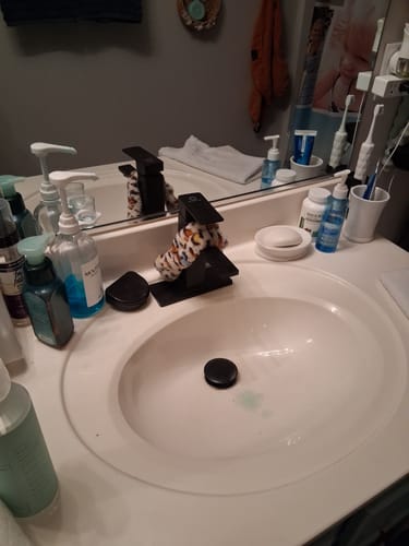 Customer's photo of a cluttered bathroom sink and countertop in a review for the Trial Pack cleaning kit.