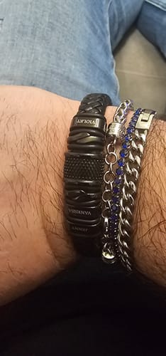 Customer's wrist wearing the personalized black bracelet, stacked with two other chain bracelets.