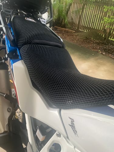 Customer's black mesh Wind Rider Seat Cover installed on a white motorcycle, viewed from the side.