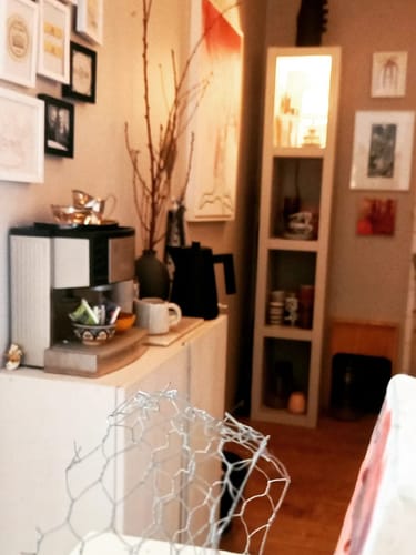 Beoordelaar toont de zwarte Alessi Plissé waterkoker in een gezellige keuken, naast een koffiezetapparaat.