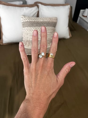 Reviewer's hand showing the gold-tone Navae Ring with two large stones on their ring finger.