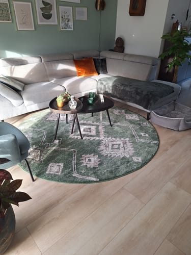 Klant toont de set van twee WOOOD Crude bijzettafels in een woonkamer.