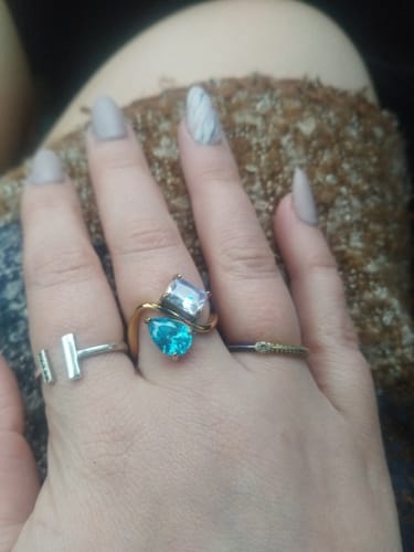 Customer wearing the two-stone Navae Birthstone Ring with a bright blue and a pale lavender stone on a gold band.
