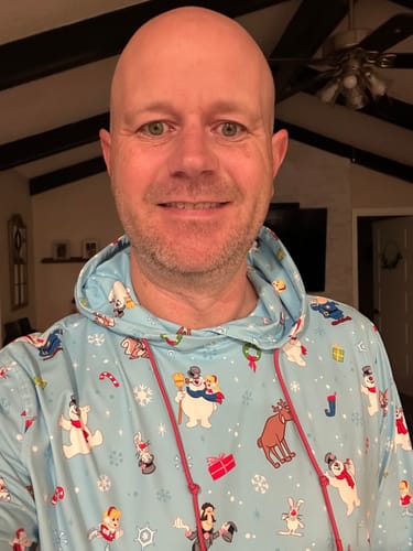 A customer wearing the light blue 'Frosty & Friends' hoodie with a colorful character print.