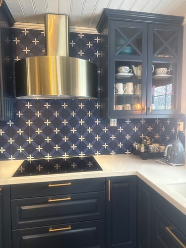 Kundes Classic Navy selvklebende backsplash installert i et stilig, marineblått kjøkken.