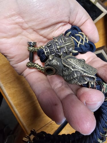 Close-up of the Vikings Bear Paracord Bracelet's ornate clasp held in a reviewer's hand for comparison.