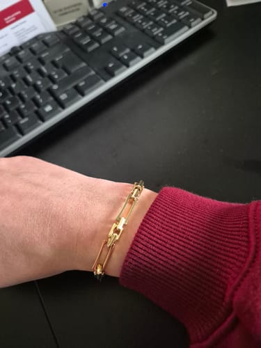 A top-down view of a reviewer wearing the shiny Lovers Chain Bracelet on their wrist.