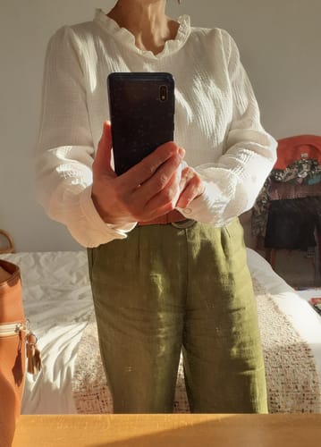 Cliente portant la blouse Fantine blanc cassé, montrant la texture de la gaze de coton et le col froufrou.