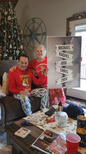 Customers happily displaying their personalized NAMES ONLY STREET SIGN canvas in a festive living room.