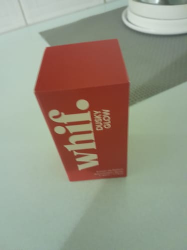 Customer's red box of Dusky Glow perfume standing on a light-colored countertop.