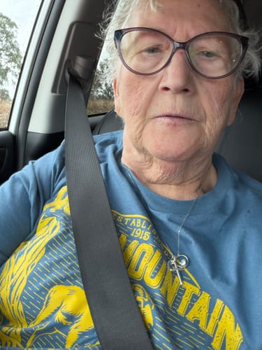 Reviewer wearing the blue Rocky Mountain National Park Vintage T-Shirt in a car.