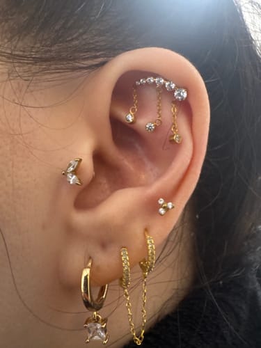 Customer's ear showing the Drippy Chained Flatback Gold earring worn in a cartilage piercing.