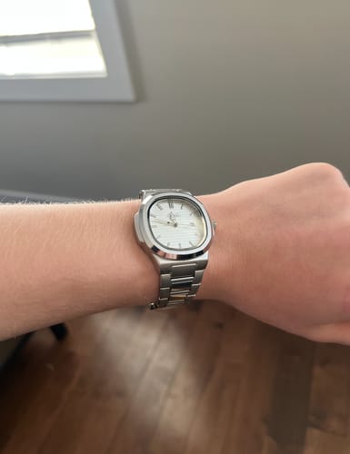 A reviewer wearing the silver Lucky Fours® Caspian watch on their wrist.