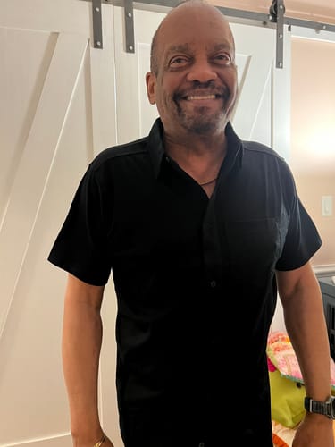 Reviewer smiling while wearing the Endi Full Button Down Shirt in black, showing its perfect fit.