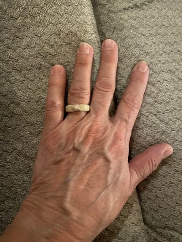 Reviewer's hand wearing the light-colored silicone ring with a central stone setting on their finger.