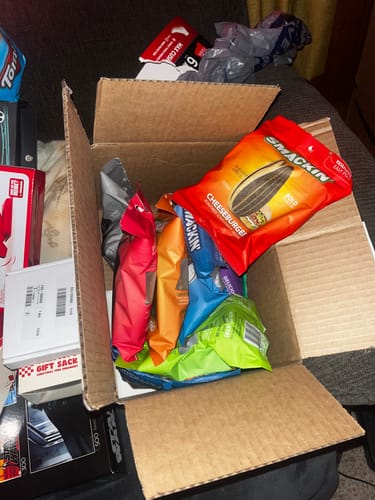Customer opens a shipping box to reveal the VARIETY PACK of colorful sunflower seed bags inside.