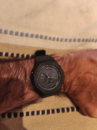 Cliente mostrando su reloj Casio G-Shock 'Casioak' totalmente negro en la muñeca.