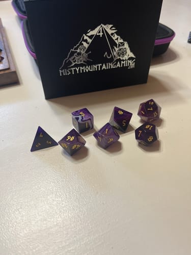 Customer's Purple Agate Stone Dice Set with gold numbers laid out in front of the branded storage box.