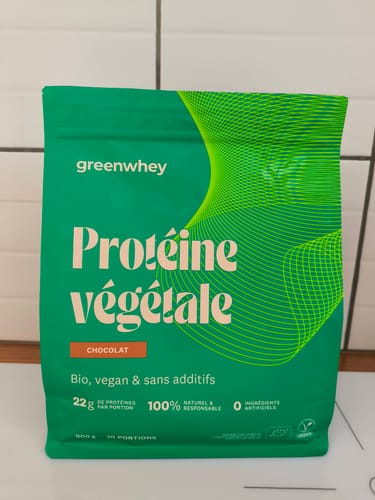 Photo d'un client du sachet vert de Protéine Végétale Bio, saveur chocolat, posé sur un comptoir de cuisine.