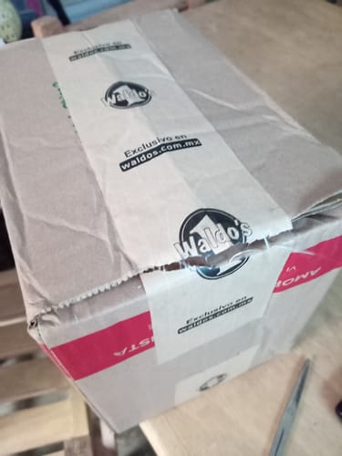 Cliente mostrando la caja de envío sellada con cinta de Waldo's para los JLab JBuds.