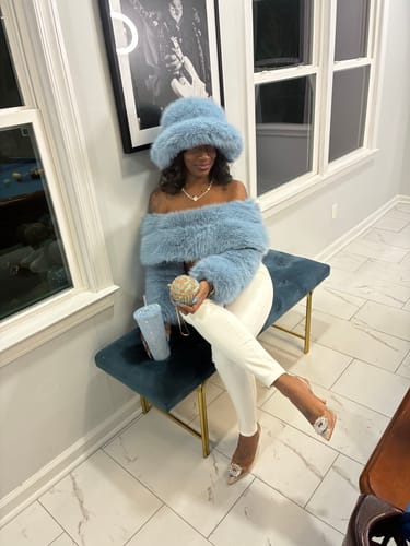 Reviewer posing indoors while wearing the light blue Faux Fur Oversized Bucket Hat.