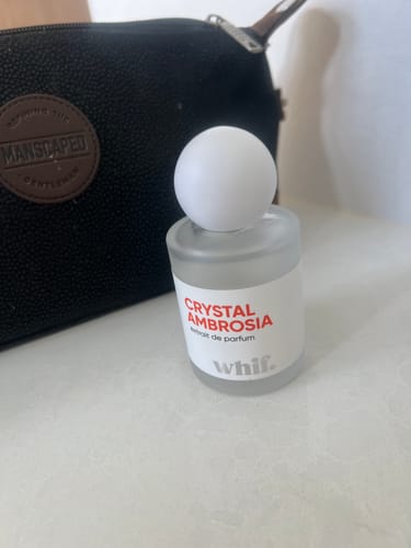 Customer's Crystal Ambrosia perfume in a frosted bottle with a white cap, shown on a counter.