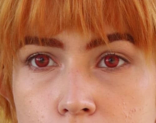 Close-up of a reviewer's eyes wearing the vibrant Milkshake Red (FD17) contact lenses, looking directly at the camera.