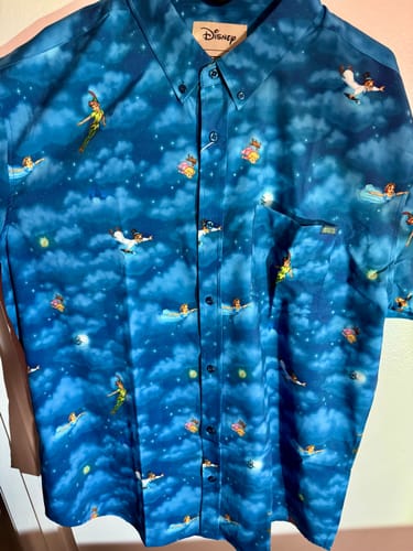 Reviewer's blue Peter Pan "You Can Fly!" shirt showing characters flying across a cloudy night sky pattern.