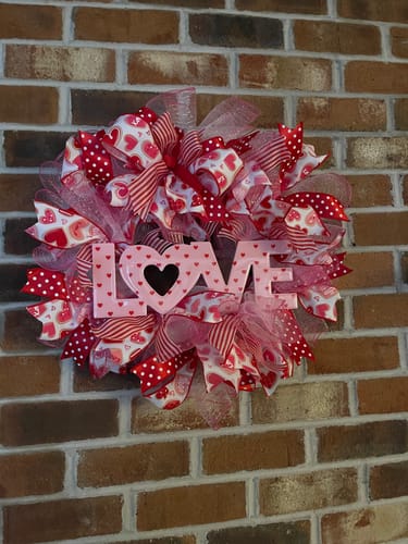 Reviewer's handmade Valentine's wreath using the Pink Metallic Mesh, with ribbons and a pink 'LOVE' sign.