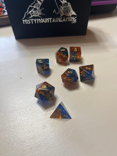 Reviewer's Ice and Fire dice set showing the blue and orange shattered glass design on a white surface.