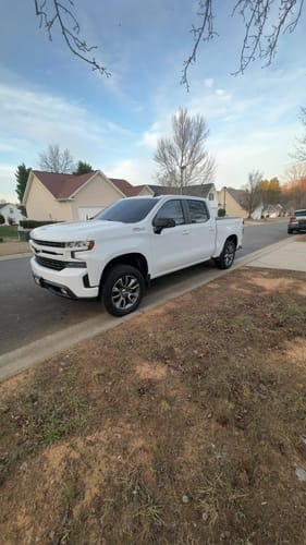 Customer's white truck parked on a residential street after installing the 3" Front Lift Kit.