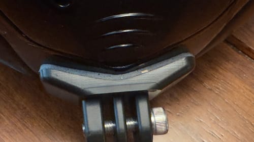Close-up: Reviewer's LS2 Rapid Camera Mount attached to the chin of a black helmet.