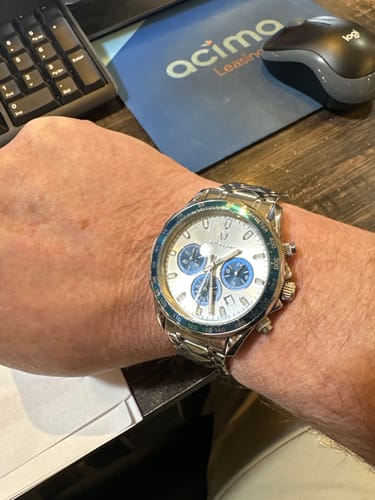 Reviewer showing their silver Lucky Fours® Chronometer with a white face and blue subdials on their wrist.