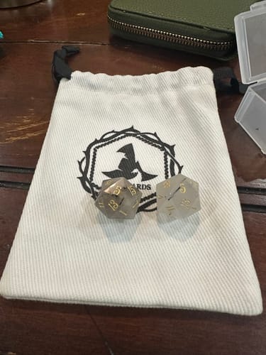 Customer's two Black Rutilated Quartz dice on a storage pouch, showing the natural variation in the gemstone.