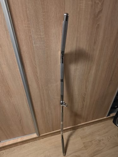 Der Latzug-Griff eines Kunden steht aufrecht an einer Holzwand in einem Raum.