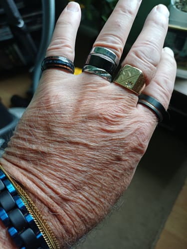 Customer wearing the Nexus ring on their pinky finger, showing its detailed abalone and wood inlay.