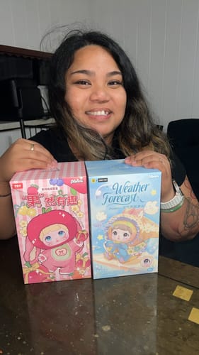 Customer happily holding the packaging for the Nommi Interesting Fruits Series plush next to another blind box.