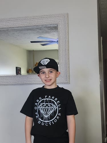 Customer wearing the black graphic Drip Tee indoors.