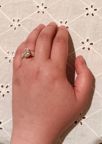 Reviewer's hand wearing the pear-cut CZ Silicone Ring with a light-colored band against a white eyelet fabric.