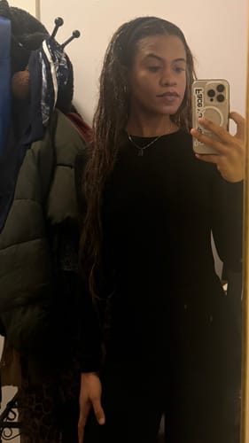 Customer taking a mirror selfie in the black NW Sculpt Crewneck Bodysuit.
