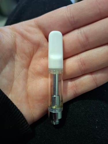 Customer holding the 1 ml Live Resin Cartridge in their palm, showing the white tip and nearly full tank.