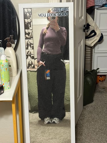 Reviewer shows the oversized fit of the black Snow Pants in a full-length mirror selfie.
