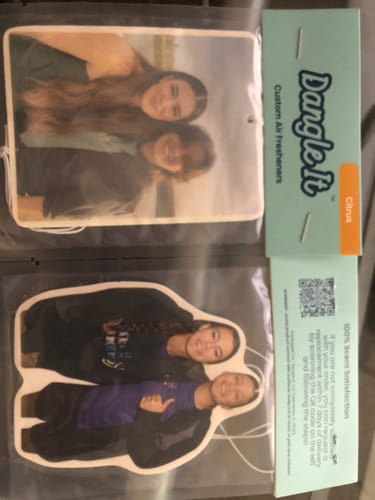 Customer showing two personalized custom air fresheners in their original packaging, each featuring a photo.